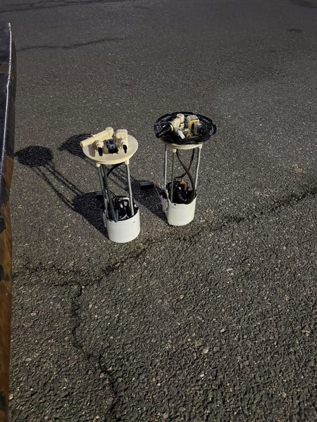 Old and new fuel pump modules side by side on pavement